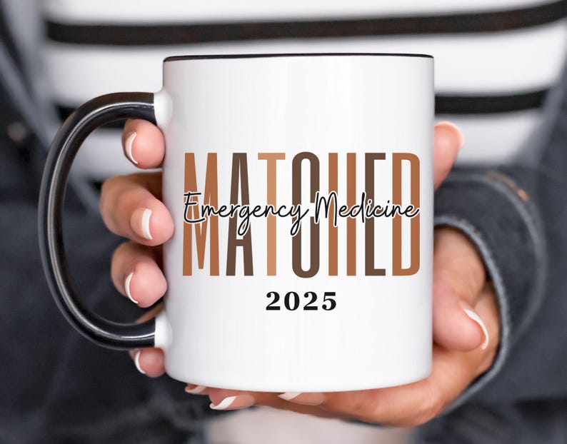 May include: White coffee mug with a black handle and black rim. The mug has the text "MATCHED Emergency Medicine 2025" printed on it in black and brown.