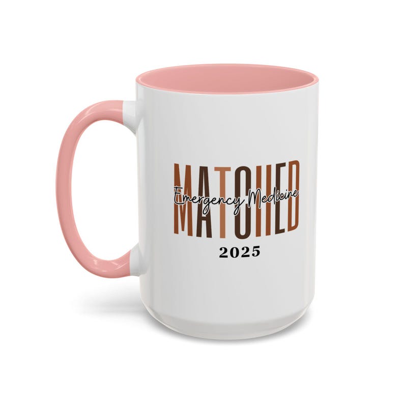 May include: White ceramic mug with a pink rim. The mug has a graphic that says "MATCHED Emergency Medicine 2025" in black and brown text.
