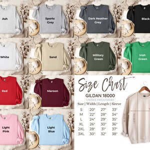 Peut inclure: Un tableau des tailles pour les sweat-shirts unisexes Gildan 18000, indiquant la largeur, la longueur et la longueur des manches en pouces pour les tailles S &agrave; 3XL. Le tableau est affich&eacute; sur un sweat-shirt beige avec un cintre.