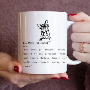 Könnte beinhalten: Eine weiße Keramiktasse mit einer Schwarzweißillustration eines französischen Bulldoggen mit Brille. Die Tasse hat einen schwarzen Text, der lautet "Tax Paws [taks paws] noun "The brief, yet frequent, breaks required by any accountant when their French Bulldog decides it's cuddle time typically during tax season."