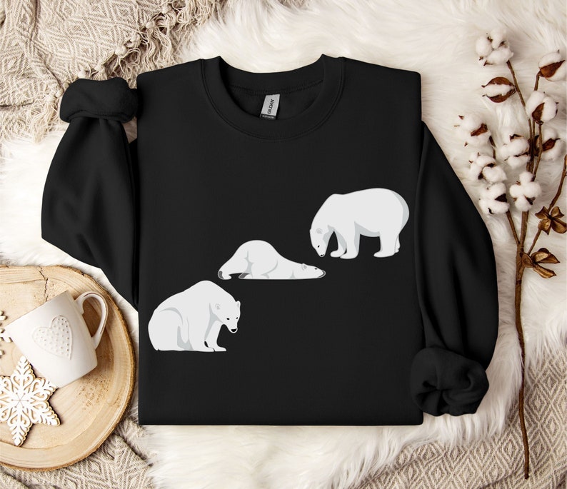 Peut inclure: Sweat-shirt noir avec un motif de trois ours polaires blancs. Deux ours sont couch&eacute;s et un est debout.