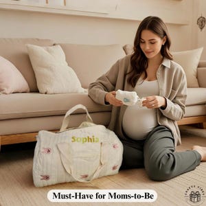 Maternity hospital bag with olive leaf pattern and custom name, great baby shower gift. Baby hospital bag displayed with folded clothes and newborn items.