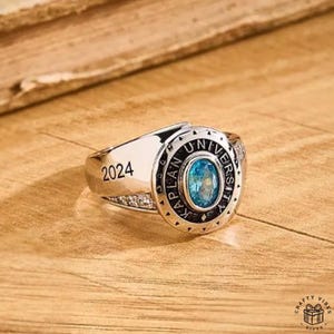 Close-up of durable metal ring with custom inscription and birthstone centerpiece