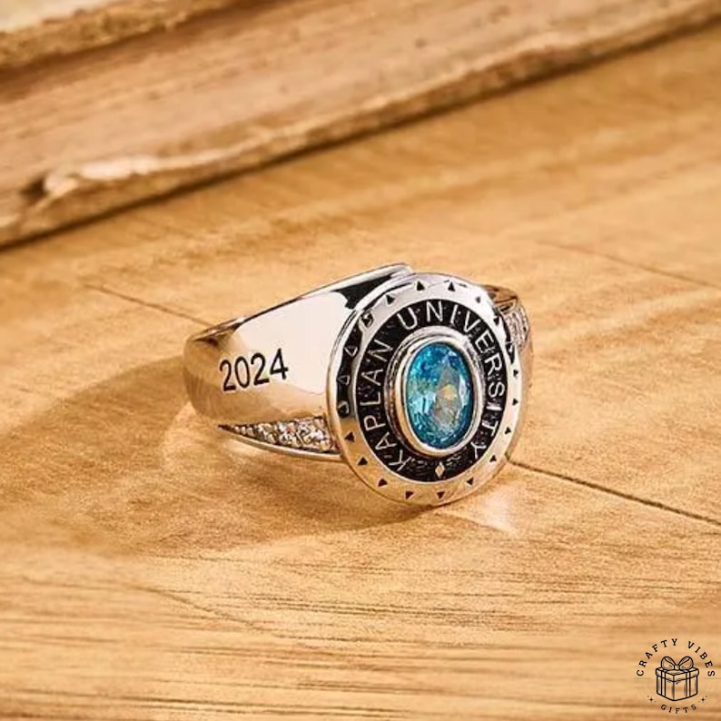 Close-up of durable metal ring with custom inscription and birthstone centerpiece