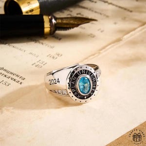 Personalized copper ring with engraved name and birthstone accent, shown in close-up view