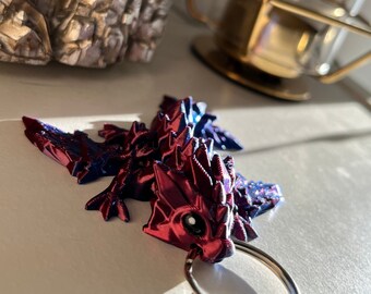 Small, shiny blue & red moving dragon with black eyes as a keychain - Limited Edition