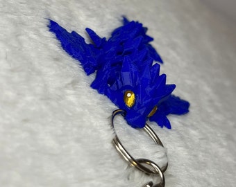Kleiner, blauer beweglicher Drache mit goldenen Augen als Schlüsselanhänger - inspiriert von Fourth Wing Sgaeyl