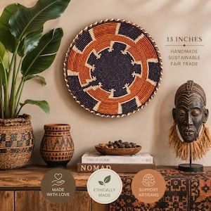 Könnte beinhalten: Ein runder Wandkorb mit einem Durchmesser von 33 cm, der ein geometrisches Muster in Dunkelmarine, gebranntem Orange und Creme aufweist. Der geflochtene Korb zeigt eine spiralförmige Mitte und strahlenförmige Segmente in Wickeltechnik.