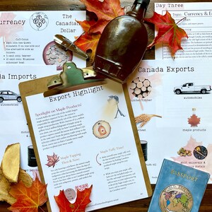 May include: A close-up of a clipboard with a document titled "Export Highlight: Spotlight on Maple Products". The document features illustrations of maple syrup production, tapping trees, and maple taffy. The document is surrounded by various items related to Canada, including a Canadian passport, a bottle of maple syrup, and a stack of wooden logs.