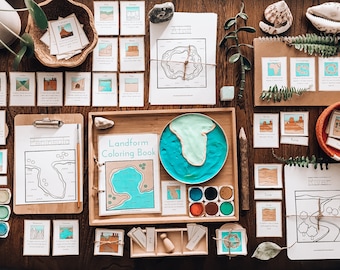 May include: A set of educational materials for learning about landforms. The set includes a coloring book, flashcards, a map, and a tray with play dough. The coloring book features a variety of landforms, including mountains, valleys, and rivers. The flashcards have pictures and descriptions of different landforms. The map is a simple outline of a continent with landforms marked. The tray has a blue play dough representing water and a green play dough representing land. The set is designed to help children learn about the different types of landforms found on Earth.