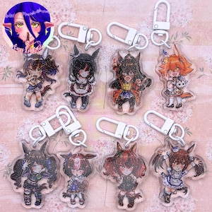 May include: A collection of eight clear acrylic keychains featuring colorful anime-style character illustrations with glitter accents. Each keychain is attached to a white plastic lobster clasp. The characters display various outfits and poses.