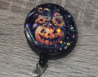 cute pumpkin badge reel with strong snap on backing great for a festive Halloween decoration.