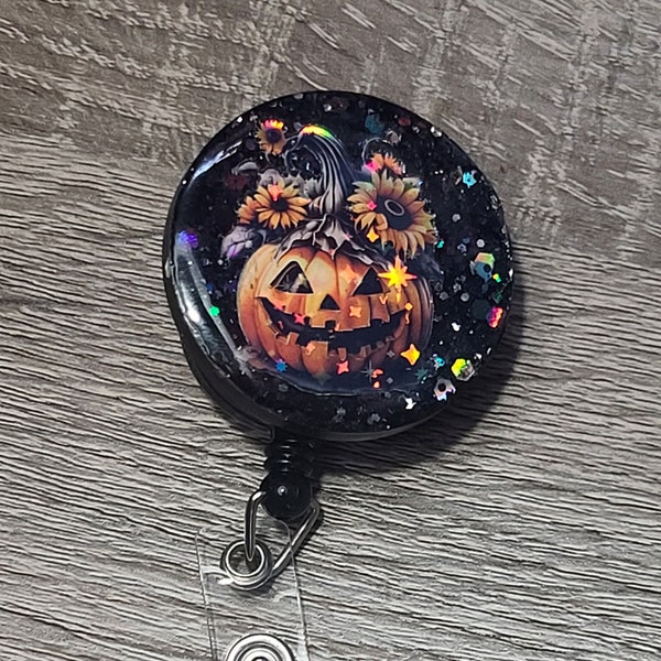 cute pumpkin badge reel with strong snap on backing great for a festive Halloween decoration.