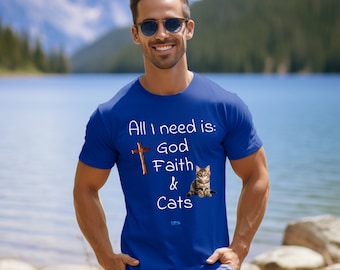 May include: A royal blue t-shirt with the text "All I need is: God Faith & Cats" in white. A brown wooden cross and a tabby cat are pictured on the shirt.