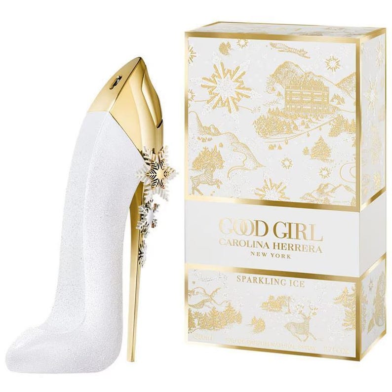 May include: A white high-heeled shoe-shaped perfume bottle with a gold heel and accents, next to a matching box. The box and bottle feature the text "GOOD GIRL" and "SPARKLING ICE". The box has a winter-themed design.