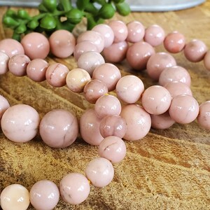 Puede incluir: Tres pulseras de piedras preciosas rosas con cuentas redondas. Las pulseras est&aacute;n hechas de piedras rosas y blancas con un brillo sutil.