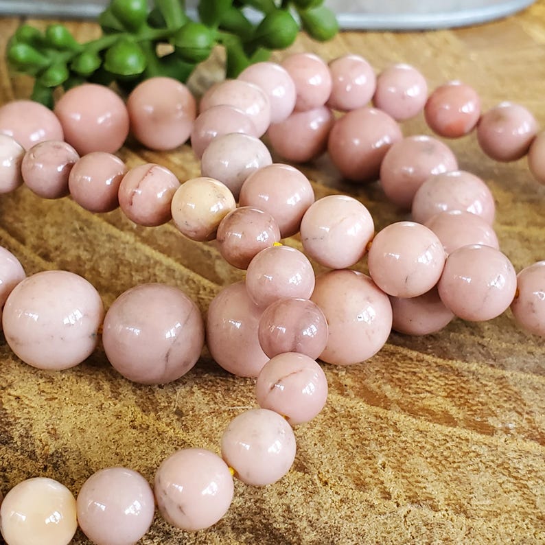 Puede incluir: Tres pulseras de piedras preciosas rosas con cuentas redondas. Las pulseras est&aacute;n hechas de piedras rosas y blancas con un brillo sutil.
