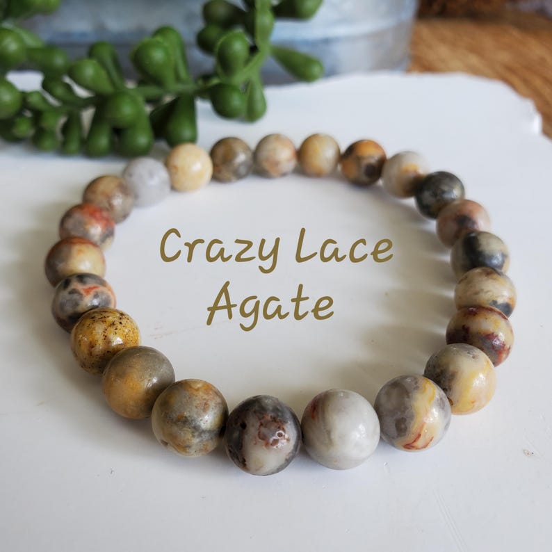 Pode incluir: Um bracelete feito de contas de &aacute;gata Crazy Lace de cor marrom, branco e amarelo.