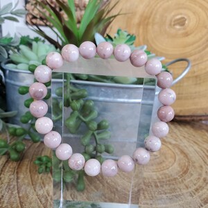 Puede incluir: Un brazalete de piedras preciosas rosa y blanco con cuentas redondas. El brazalete est&aacute; hecho de piedras naturales y es un hermoso accesorio para cualquier ocasi&oacute;n.