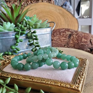 May include: A rustic wooden sign with the text "Welcome to our home" in a handwritten style. The sign features a distressed finish and a simple, inviting design, perfect for a front porch or entryway.