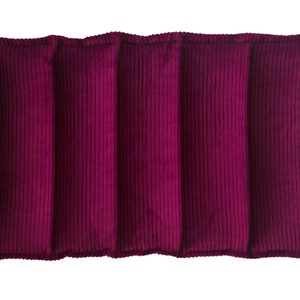 May include: A rectangular, claret-coloured heating pad with a corduroy texture. The pad is divided into five vertical sections, each with a ribbed pattern. The edges are neatly finished, and the overall design is simple and functional.