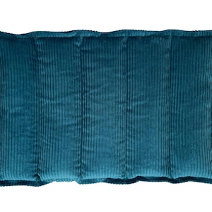 May include: A teal corduroy cushion with a rectangular shape. The cushion features a ribbed texture and a soft, plush appearance. The edges are neatly finished, and it is set against a white background.
