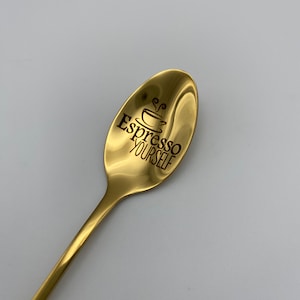 May include: A gold-colored spoon with a black engraved design that says "Espresso Yourself" with a small coffee cup icon.
