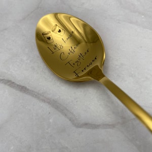 Puede incluir: Cuchara de oro con la inscripción "Let's have coffee together forever" y dos tazas de café con corazones.