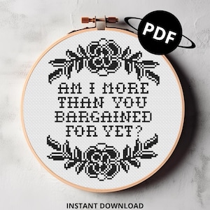 May include: Black and white cross stitch pattern with floral accents and the text "Am I more than you bargained for yet?" in a hoop.