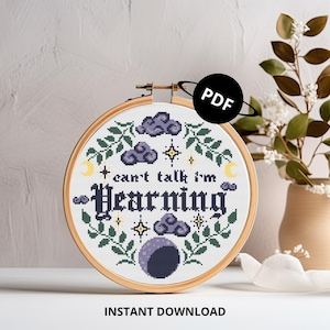 Op de afbeelding: Een kruissteekpatroon met een maan, wolken en sterren met de tekst "Can't talk I'm learning". Het patroon is in een houten borduurring. De afbeelding bevat de tekst "PDF" en "Direct downloaden".