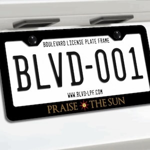 May include: Black license plate frame with the text "BLVD-001" and "PRAISE THE SUN". The frame also includes the text "Boulevard License Plate Frame" and "www.BLVD-LPF.com".