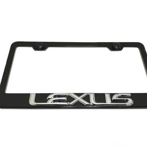 Puede incluir: Un marco de matrícula rectangular negro con la palabra LEXUS en letras metálicas plateadas en relieve a lo largo del borde inferior. El marco incluye dos cubiertas de tornillos circulares negras en las esquinas superiores.