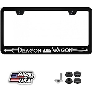 May include: Black license plate frame with the text "DRAGON WAGON" in white. Includes mounting hardware and a "MADE IN THE USA" sticker. The frame has a rectangular shape with rounded corners.