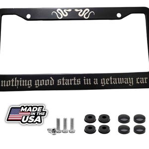 May include: Black license plate frame with the text "nothing good starts in a getaway car" in a gothic font. The top of the frame has a snake design. Includes mounting hardware and a "Made in the USA" sticker.