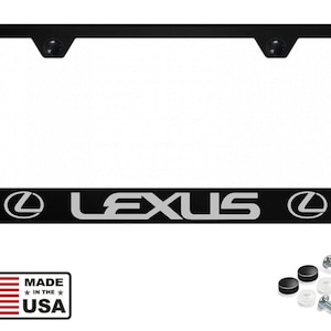 Puede incluir: Marco de matrícula negro con la palabra "LEXUS" en letras plateadas y el logotipo de Lexus. Incluye accesorios de montaje y una etiqueta "MADE IN THE USA".