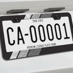 May include: A black license plate frame displaying the registration number "CA-00001" in a bold black font. The frame has a white background with the text "YOUR STATE" and "PREMIUM LICENSE PLATE FRAME". The frame has a decorative pattern.