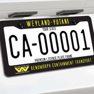 May include: Black license plate frame with the text "WEYLAND-YUTANI" and "CA-00001". The frame also includes the text "PREMIUM LICENSE PLATE FRAME" and "XENOMORPH CONTAINMENT TRANSPORT".