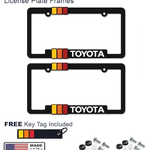 Puede incluir: Dos marcos negros para matrículas Toyota Retro con un diseño de rayas amarillas, naranjas y rojas. La palabra "TOYOTA" está en blanco. Incluye un llavero y hardware. Hecho en los EE. UU.