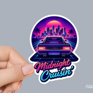 May include: A sticker featuring a retro-style car driving on a neon-lit road towards a city skyline at sunset. The sticker has the words "Midnight Cruisin'" in a gradient font.