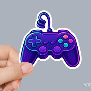 May include: A vibrant sticker of a video game controller in shades of purple, blue, and pink. The controller features a cross-shaped directional pad, colored buttons, and a looped cable. The design has a neon glow effect and a white border.