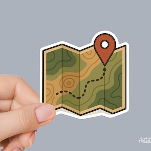 May include: A sticker featuring a stylized map with a red location marker. The map has a green and tan color scheme with a dotted line indicating a route. The sticker is held against a gray background.