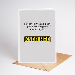 May include: A light gray greeting card with black text that reads: For your birthday, I got you a personalised number plate: followed by a yellow and black graphic of a license plate with the text KNO8 HED. The card sits on a brown envelope.