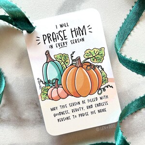 May include: A rectangular gift tag with the text "I WILL PRAISE HIM IN EVERY SEASON" and a pumpkin illustration. The tag features a teal ribbon and a watercolor design of pumpkins in orange, teal, and pink. The text "MAY THIS SEASON BE FILLED WITH GOODNESS, BEAUTY, AND ENDLESS REASONS TO PRAISE HIS NAME" is also included.