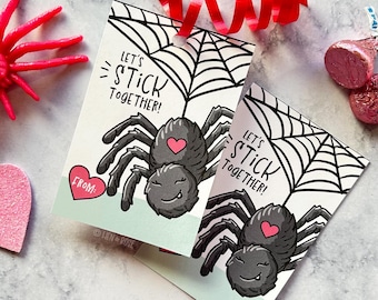 Puede incluir: Dos etiquetas de regalo rectangulares de papel con una ilustración de una araña negra con un corazón rosa en el lomo, una telaraña y el texto "LET'S STICK TOGETHER!" en tinta negra. Una etiqueta incluye un corazón rosa con la palabra "FROM:".