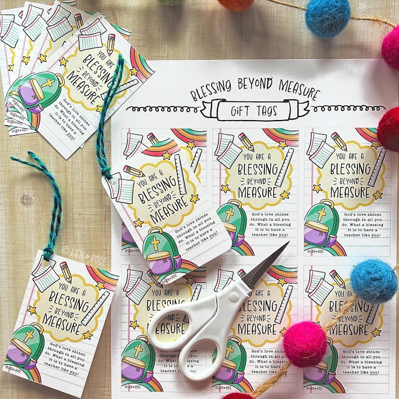 May include: Gift tags with the text "You are a Blessing Beyond Measure" featuring a backpack, rainbow, and school supplies. The tags are white with a teal string. A pair of white scissors is also in the image.