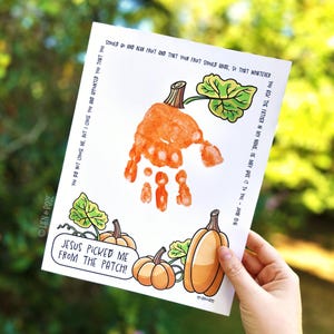 May include: A white paper with a handprint pumpkin design. The pumpkin is made from an orange handprint with a brown stem and green leaf. The text "JESUS PICKED ME FROM THE PATCH!" is in a speech bubble.