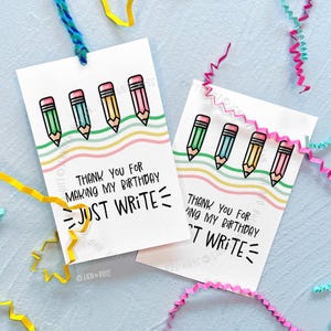 May include: Two white gift tags with colorful pencil illustrations and the text "Thank you for making my birthday, just write." Each tag has a blue string for hanging. The pencils are green, blue, yellow, and pink.
