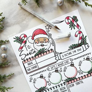 May include: A festive letter to Santa Claus, featuring a hand-drawn Santa Claus illustration with a red hat and white beard. The letter includes spaces for name, age, and gift wishes, along with candy cane and ornament decorations. A silver pen rests on the paper.
