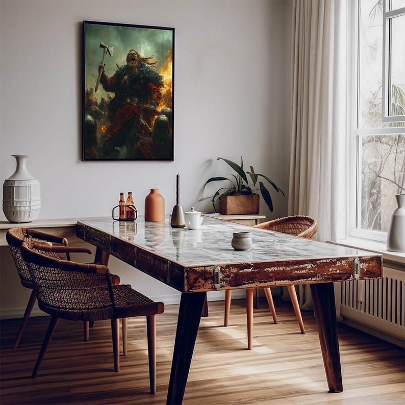 May include: A rustic wooden dining table with a distressed finish, featuring a light brown top and dark brown legs. Two wicker chairs are placed on either side of the table, with a framed painting of a warrior figure hanging on the wall behind the table.