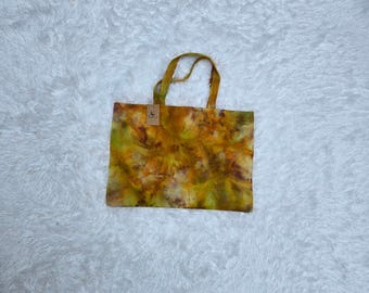 May include: A yellow, green, and orange tie-dye tote bag with a small tag that says "Luna Handmade".
